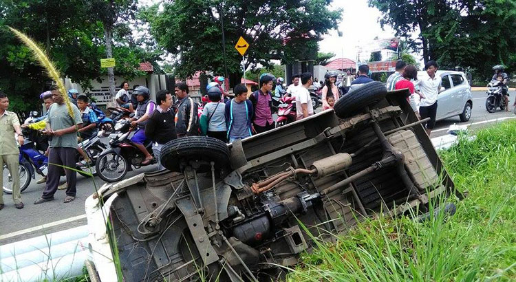 Kondisi mobil nyungsep di siring jalan menjadi tontonan pengendara yang melintas