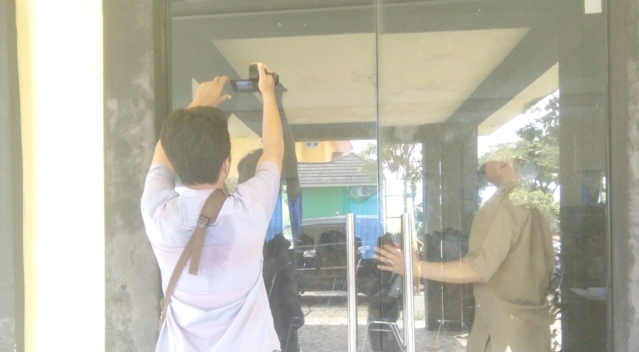 Salah satu wartawan televisi nampak kesulitan mengambil gambar kegiatan Plt Bupati Bengkulu Selatan karena dilarang masuk ke aula