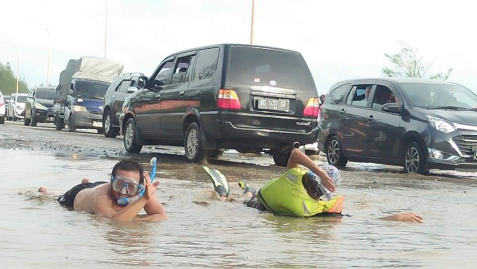 Aksi warga berenang di jalan berkubang kawasan wisata Pantai Berkas Kota Bengkulu