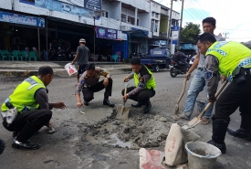Anggota Satlantas Polres Kepahiang memperbaiki jalan rusak