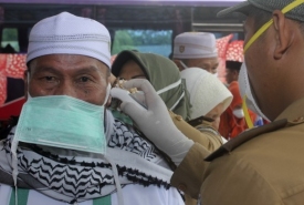 Saat petugas memeriksa suhu tubuh seorang jemaah haji